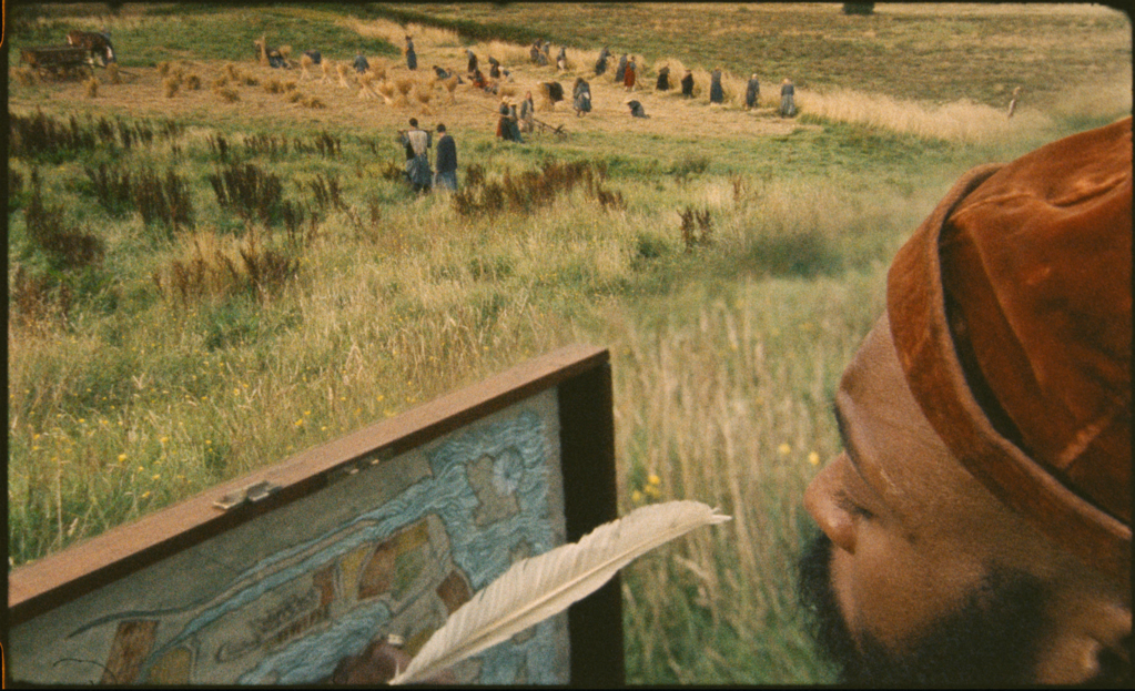 Plan du peintre dessinant sa carte dans le film HARVEST